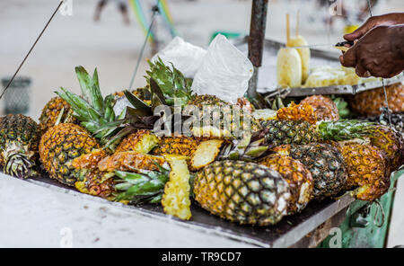 Brazilian man selling fresh pineapple from a cart on the Boa Viagem beach in Recife, Pernambuco, Brazil. Stock Photo