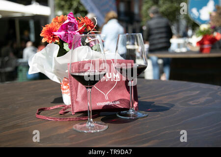 Two wine glasses with red wine and flowers on the table during traditional wine and food show event VINUM in Alba Italy Europe Stock Photo