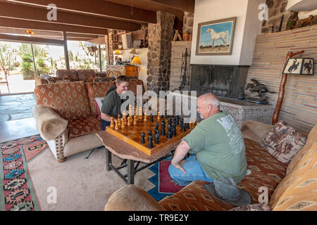 Father and son play chess in the common room at White Stallion Ranch, a dude ranch just outside Tucson, AZ. Stock Photo