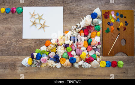 Summer time concept with sea shells and starfish on white paper. Top view. Stock Photo
