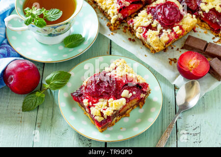 Sweet pie, tart with fresh plum. Delicious cake with plum on kitchen table. Stock Photo