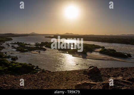 The early evening sun is reflected brightly in the waters of the third cataract of the river Nile in the Nubian region of Sudan Stock Photo