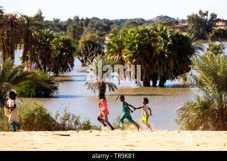 Children of El Kab village play on the banks of lake Merowe formed by the Merowe dam on the Nile river Stock Photo