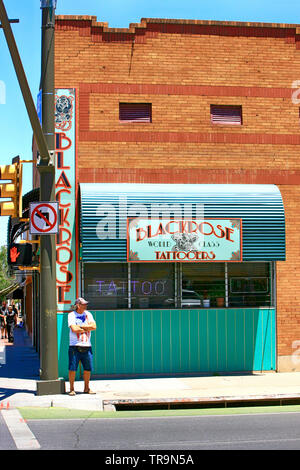 Man standing outside the BlackRose Tattoo parlor on Broadway Blvd in Tucson AZ