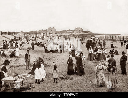 A 19th Century view of  holiday - makers on the beach at Walton-on-the-Naze, a small town in Essex, England, on the North Sea coast.  Originally, it was a farming village situated miles inland, but over the centuries a large extent of land has been lost to the sea due to coastal erosion. Stock Photo