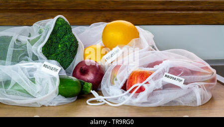 Fruit and Vegetables in reusable mesh bags, with reuse me labels, on kitchen counter, authentic real plastic free eco friendly shopping Stock Photo