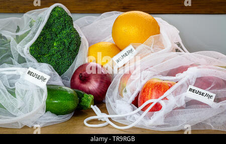 Fruit and Vegetables in reusable mesh bags, with reuse me labels, on kitchen counter, authentic real plastic free eco friendly shopping Stock Photo