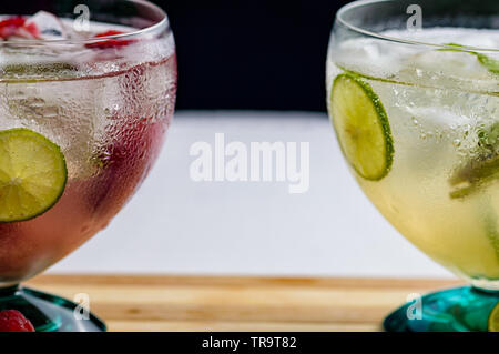 Mojito and raspberry mojito rum cocktail drinks with ingredients, limes, lemons, mint, brown sugar and raspberries. Concept for restaurants, food and Stock Photo