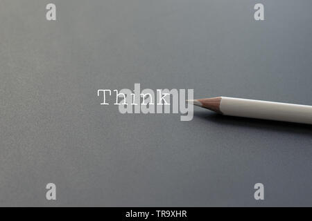 white pencil on black backgrounds with text Think and copy space Stock Photo
