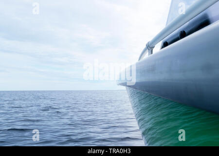 Side view Speeding fishing motor boat with drops of water. Blue ocean sea water wave reflections with fast fishing yacht. Motor boat in the blue ocean Stock Photo