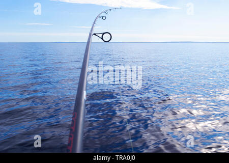 Fishing rod spinning ring with the line close-up. Fishing rod over the crystal still water. Fishing rod rings. Fishing tackle. Fishing spinning reel. Stock Photo