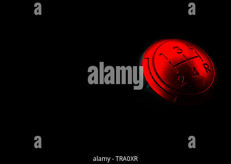 Close up view of a red gear lever shift isolated on black background. Manual gearbox. Car interior details. Car transmission. Soft lighting. Abstract Stock Photo
