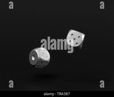 Two Rolling Silver Casino Dice on Black Background showing five and one. Stock Photo