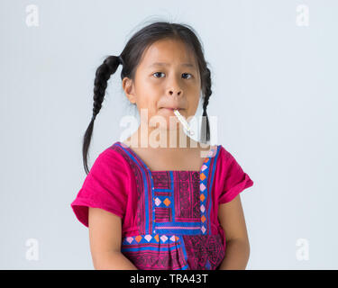 Little cute girl kid sitting with mercury thermometer in her mouth for checking temperature. Stock Photo