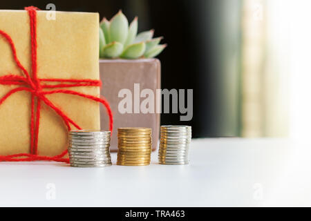 Investment and interest Concept, Saving money with gift box and little tree Stock Photo