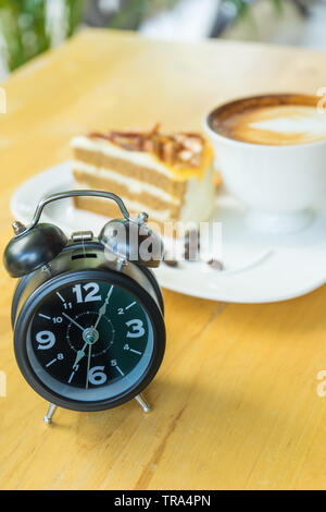 Alarm clock on table with blurred hot coffee background, Stock Photo