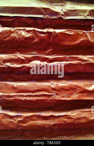 Old red crumpled iron painted horizontal corrugated fence background Stock Photo