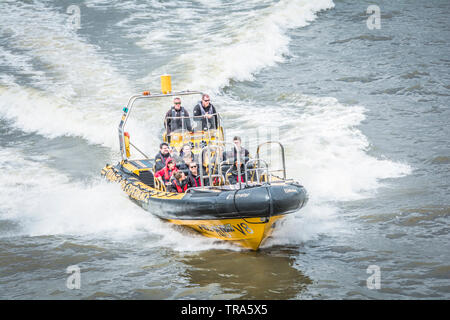 Tourists enjoying a Thames Rib Experience inflatable boat on the river Thames in London, England, UK Stock Photo