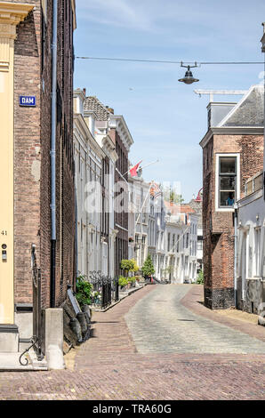 Middelburg, The Netherlands, May 30, 2019: street in the old town lined with two or three storey houses with brick or plaster facades on a sunny day Stock Photo