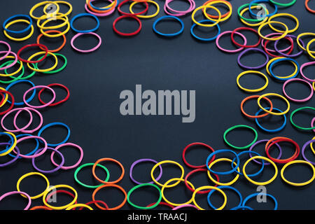 Information sharing concept, colorful rubber band on black background with copy space Stock Photo