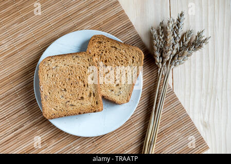 Two Slices of Toast Bread and Ear of Wheat on a Wooden Table Setup Stock Photo