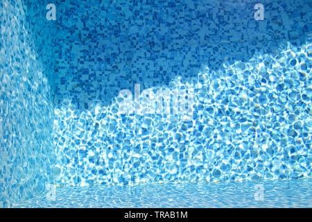 Swimming pool bottom caustics ripple and flow with waves background. Surface of blue swimming pool, background of water in swimming pool. Stock Photo