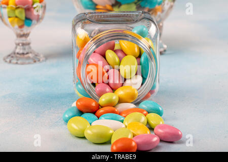 Sweet sugar candies in glass jars on brown vintage wooden background Stock Photo
