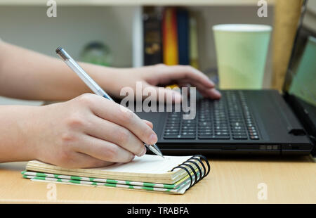 Working on the computer and taking notes in the office, close up Stock Photo