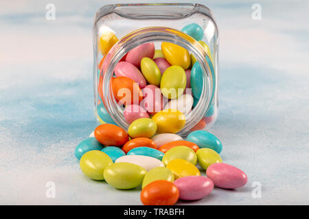 Sweet sugar candies in glass jars on brown vintage wooden background Stock Photo
