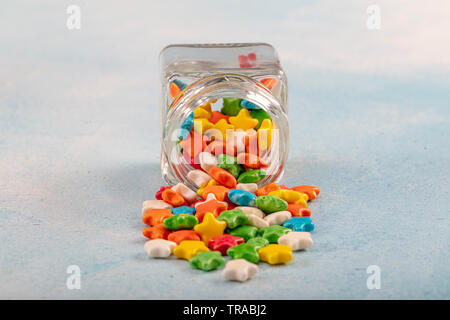 Sweet sugar candies in glass jars on brown vintage wooden background Stock Photo