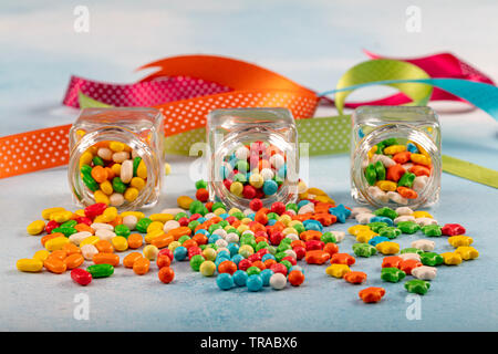 Sweet sugar candies in glass jars on brown vintage wooden background Stock Photo