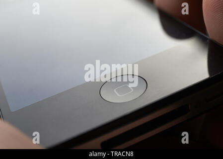 Amazing close up of a finger about to press the home button of a touch screen mobile device Stock Photo