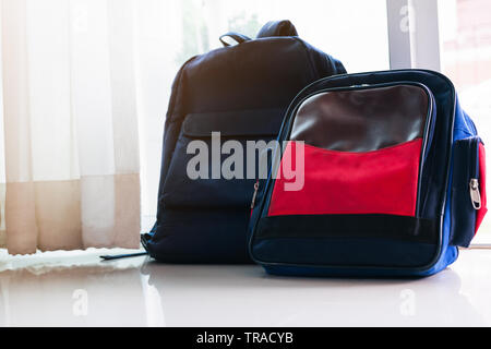 Back to school concept. Blue  backpack leans on the glass door for two kids Stock Photo