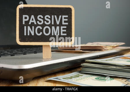 Passive income concept. Notebook and stack of cash. Stock Photo