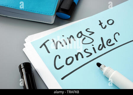Man writes things to consider list in note. Stock Photo