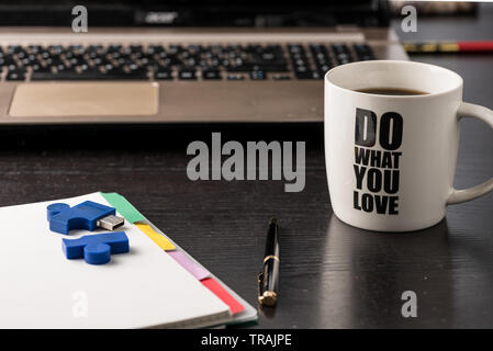 still life with blocknote, labtop, pen and a white mug of coffee over a black office desk. symbol of job Stock Photo