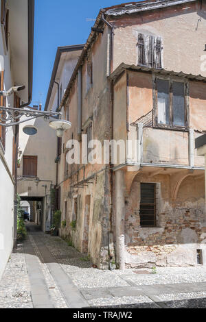 cirtyscape with run down old house in narrow alley, shot at Mediterranean little town of Portogruaro, Venezia, Veneto, Italy Stock Photo