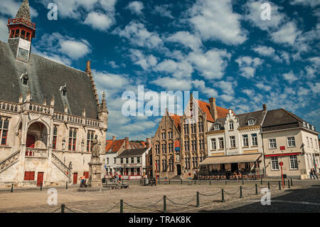 Gothic-style building of the town hall and people in the central square of Damme. A small and charming old village in Belgium countryside. Stock Photo