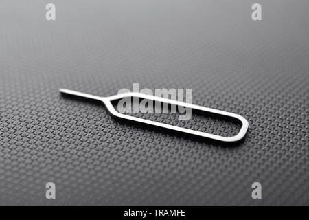sim ejector tool on black textured background Stock Photo