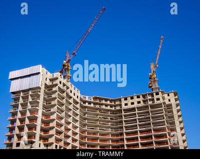 Two cranes on the roof of a house under construction Stock Photo