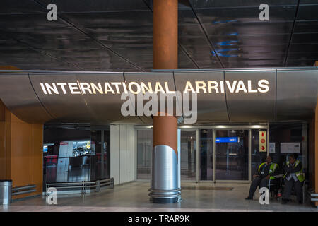 International Arrivals Hall with closed doors and two African ladies sitting on chairs at Cape Town International Airport in South Africa Stock Photo