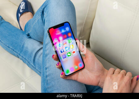 Sankt-Petersburg, Russia, May 30, 2018: Apple iPhone X in woman hands with icons of social media facebook, instagram, twitter, snapchat application on Stock Photo