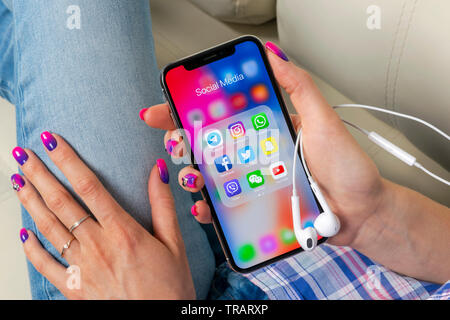 Sankt-Petersburg, Russia, May 30, 2018: Apple iPhone X in woman hands with icons of social media facebook, instagram, twitter, snapchat application on Stock Photo