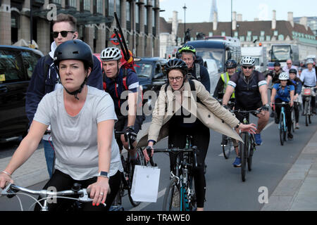 Cyclists cycling home after work commute riding bikes on Bridge Street outside Houses of Parliament in Westminster London UK Britain KATHY DEWITT Stock Photo