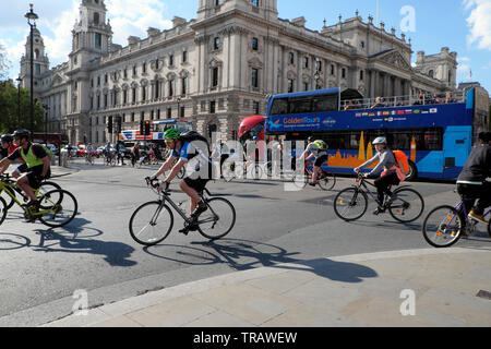 Cyclists cycling home after work riding bikes near the Houses of Parliament in Westminster London Stock Photo