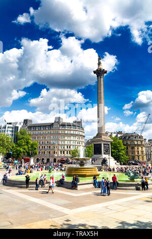 Tourists gathered in Trafalgar Square, fountain and Nelson's Column, London, UK