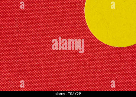 Macro image a yellow sticker on the texture of a red book cover Stock Photo