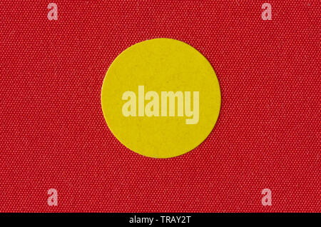 Macro image a yellow sticker on the texture of a red book cover Stock Photo