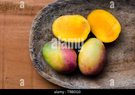 Ripe mangoes on a rustic table background Stock Photo