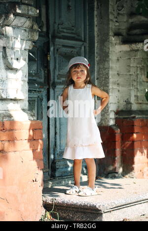 Little girl stands in front of the door Stock Photo